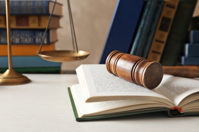 Wooden gavel, scales of justice and books on table. Law concept