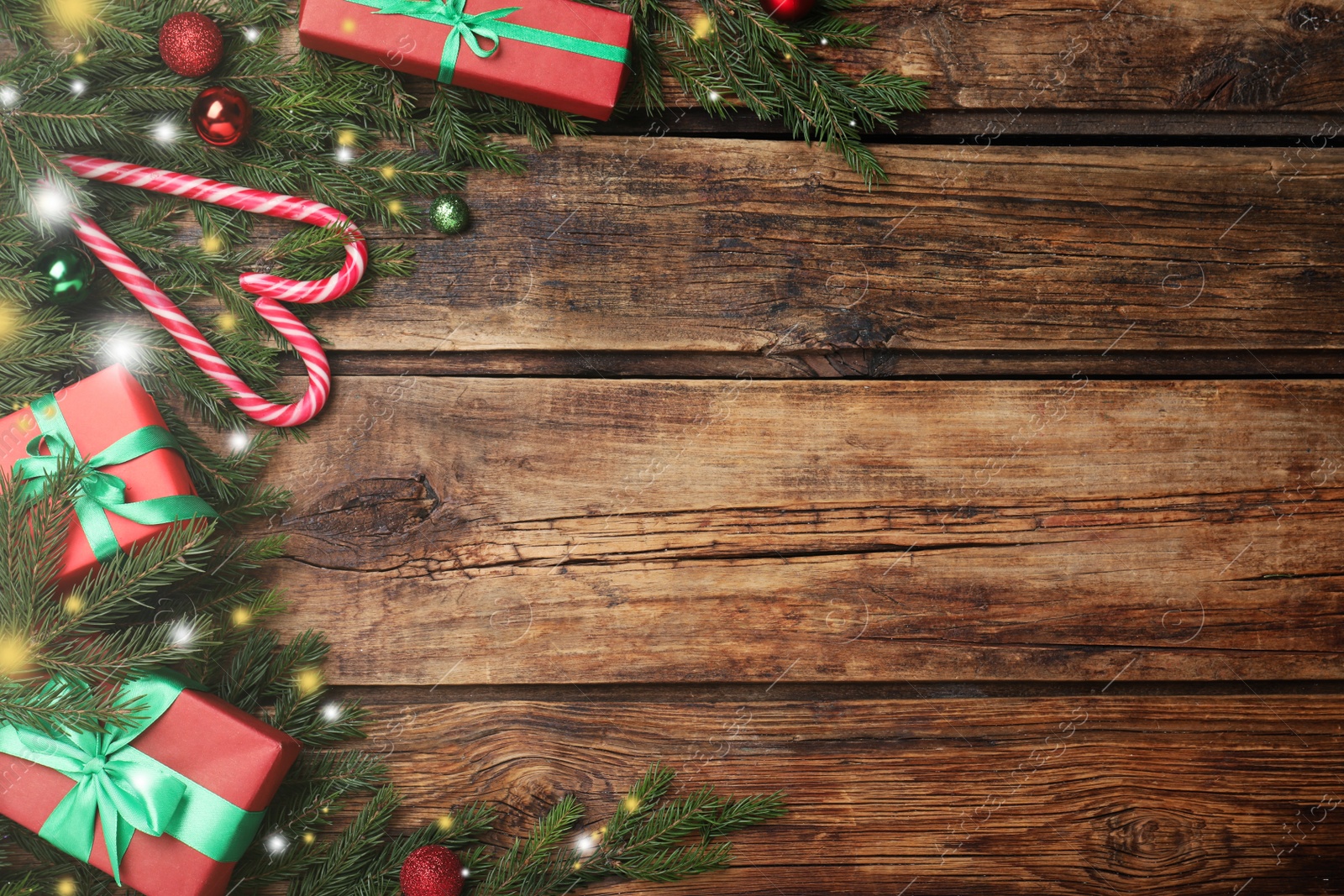 Photo of Christmas greeting card with space for text. Flat lay composition of fir tree branches and festive decor on wooden background