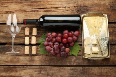 Photo of Flat lay composition with tasty red wine and snacks on wooden table