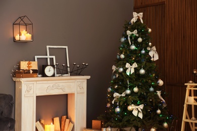 Photo of Stylish room interior with Christmas tree and decorative fireplace