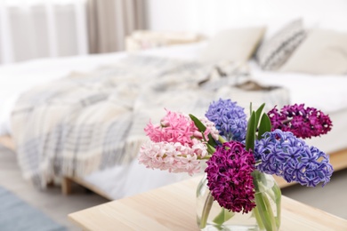 Photo of Beautiful hyacinths in glass vase on table indoors, space for text. Spring flowers