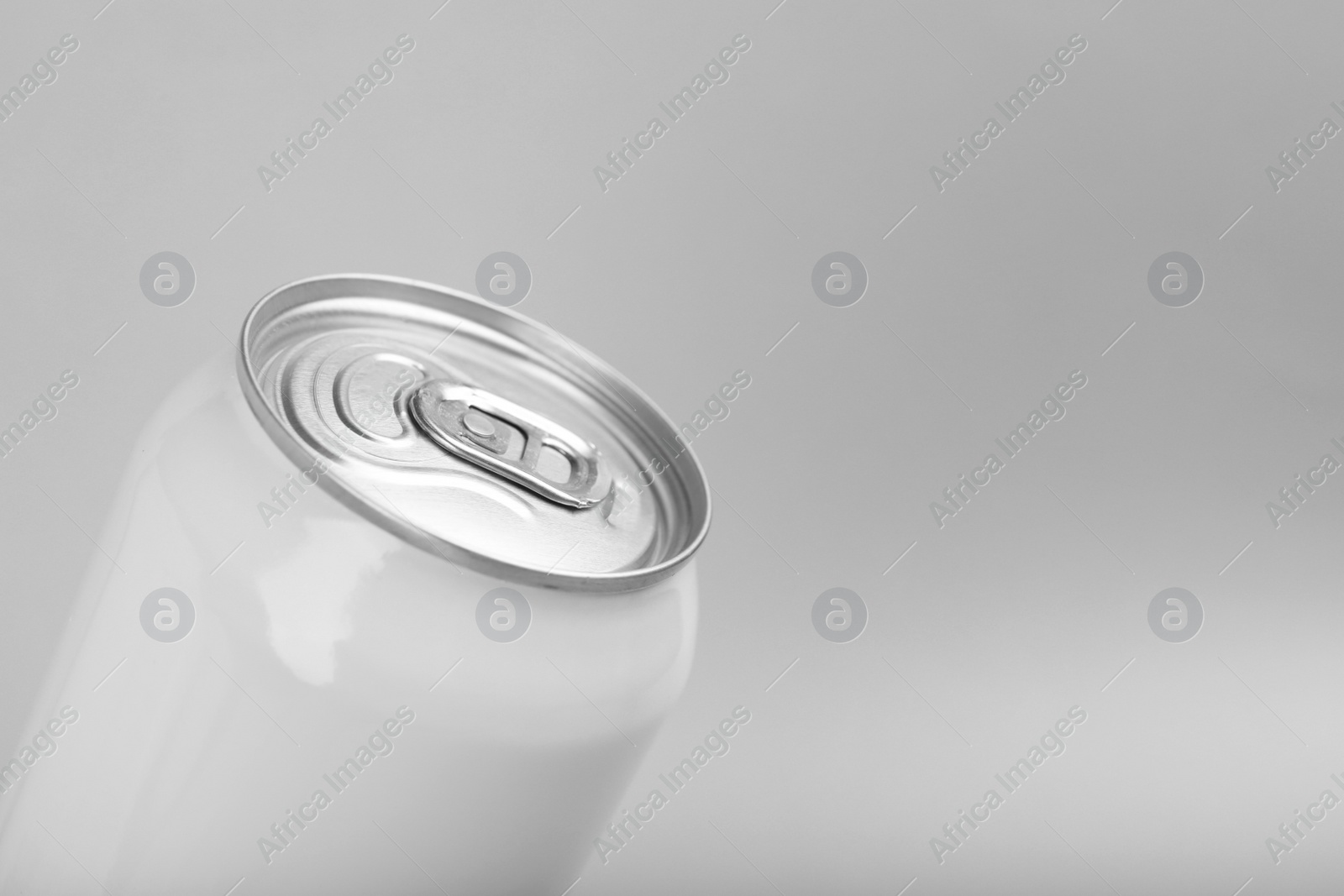 Photo of White can of energy drink on light grey background, closeup. Space for text