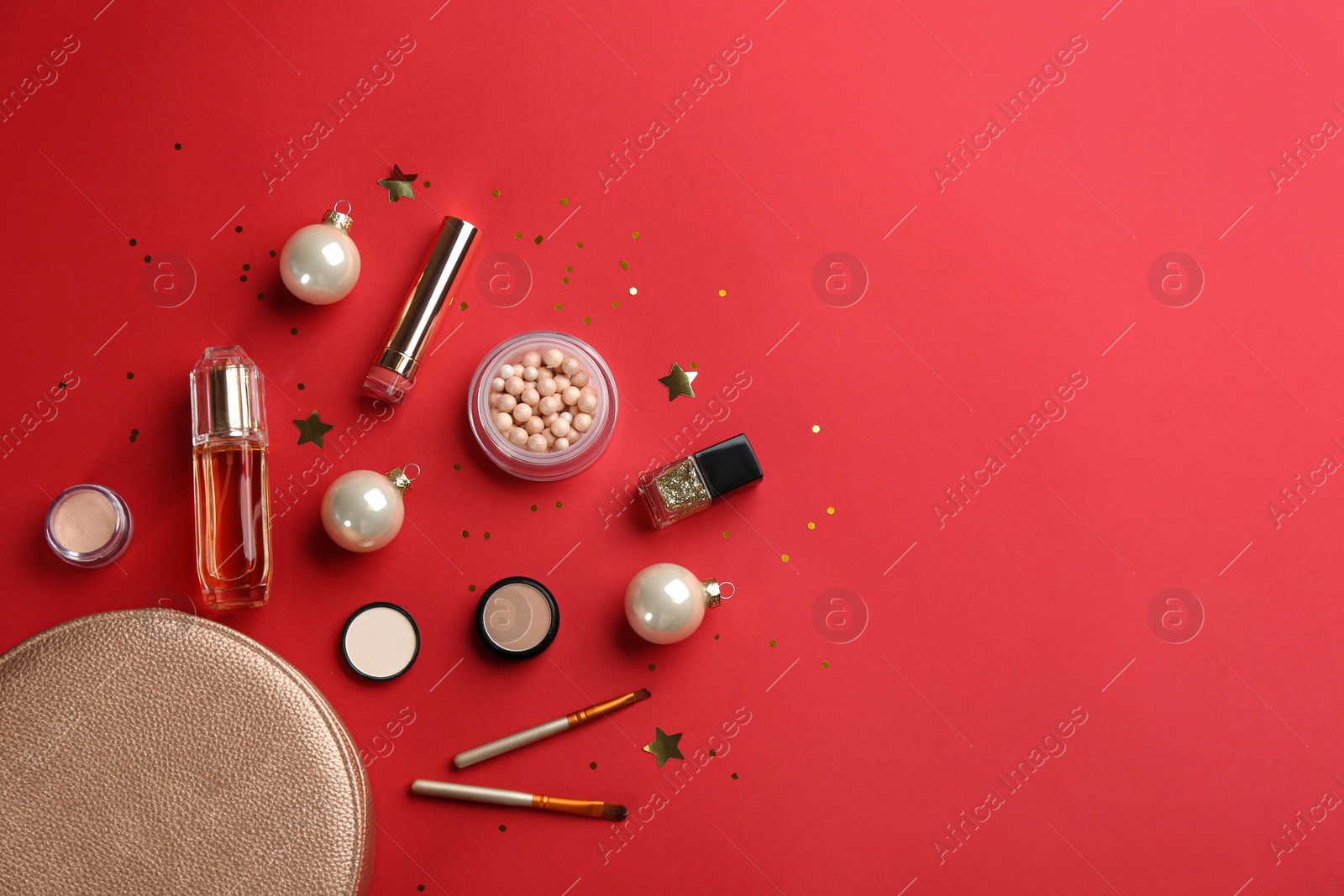 Photo of Flat lay composition with decorative cosmetic products on red background, space for text. Winter care