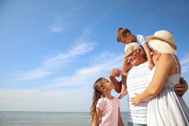 Photo of Cute little children with grandparents spending time together near sea