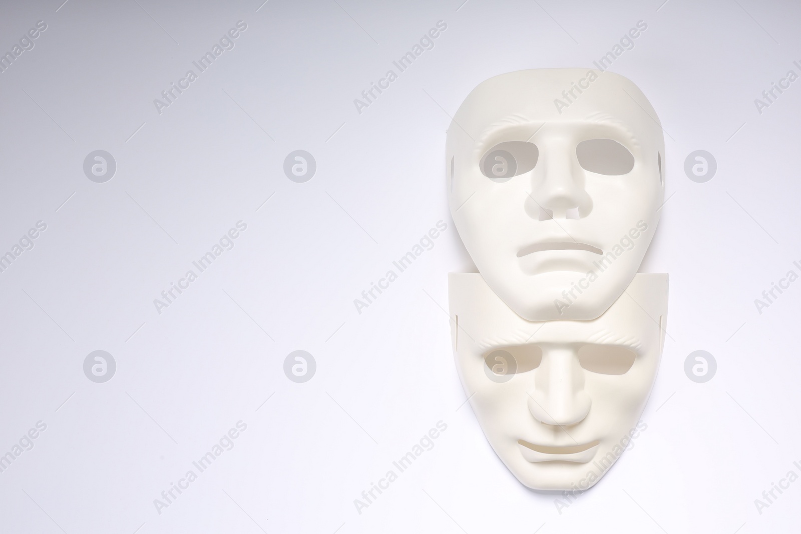 Photo of Theater arts. Two masks on white background, top view. Space for text