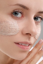 Photo of Woman with cosmetic product on her face, closeup. Spa treatments