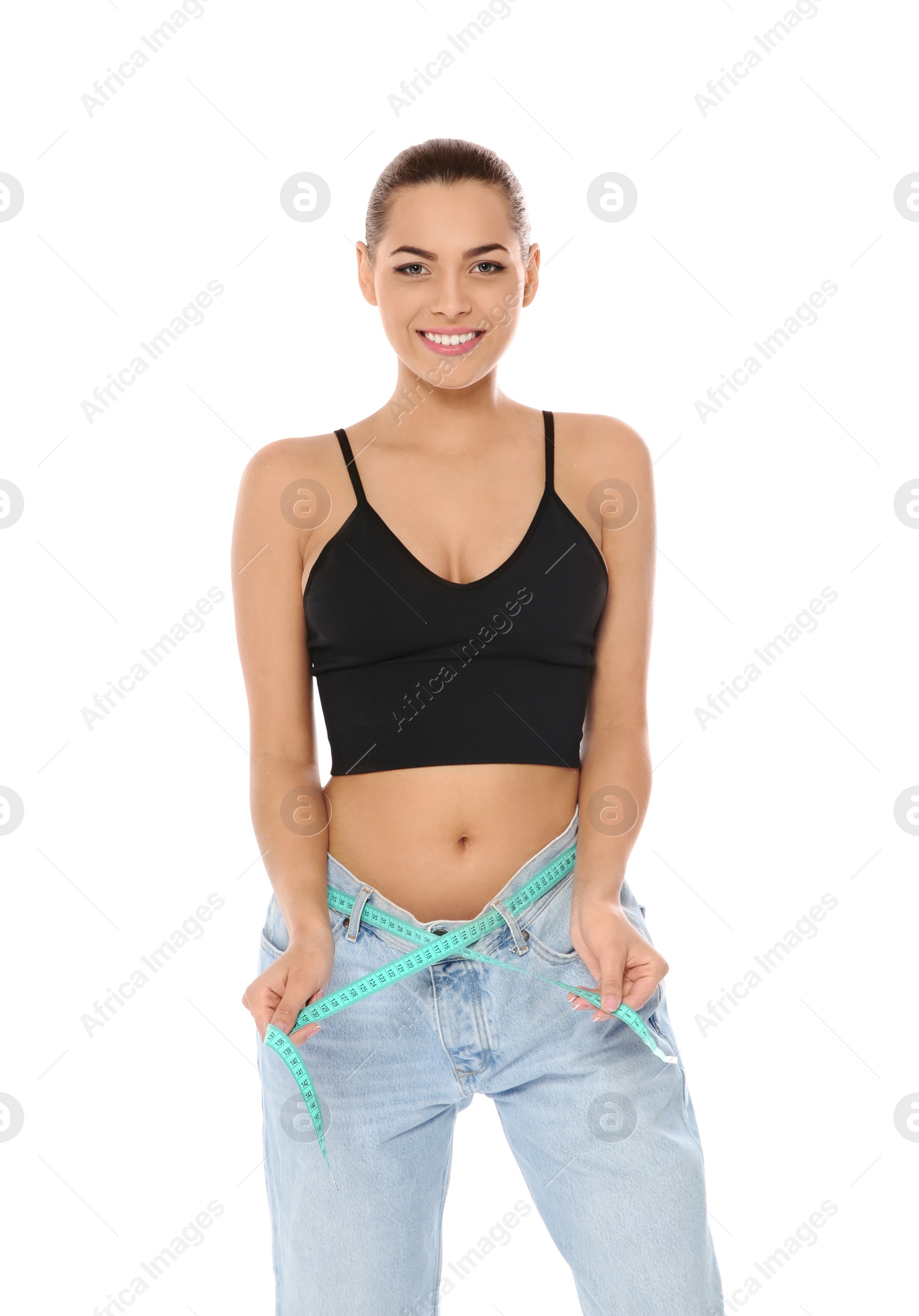 Photo of Slim woman in oversized jeans with measuring tape on white background. Weight loss