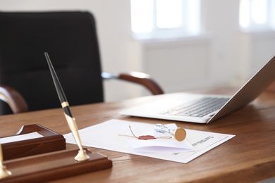 Photo of Vintage stamp, laptop and documents on desk in notary's office