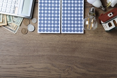 Photo of Flat lay composition with solar panels and money on wooden table. Space for text