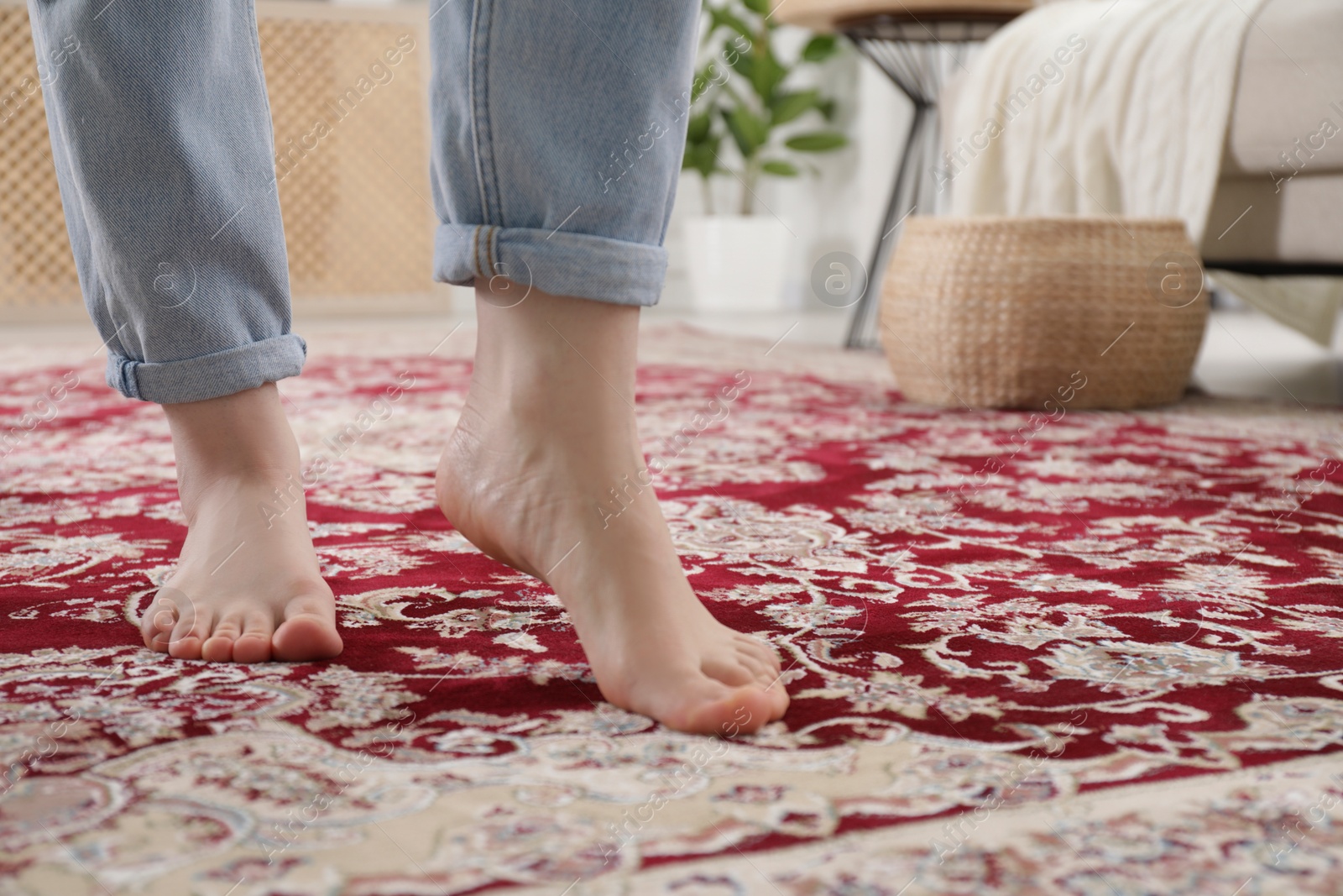 Photo of Woman standing on carpet with pattern at home, closeup. Space for text