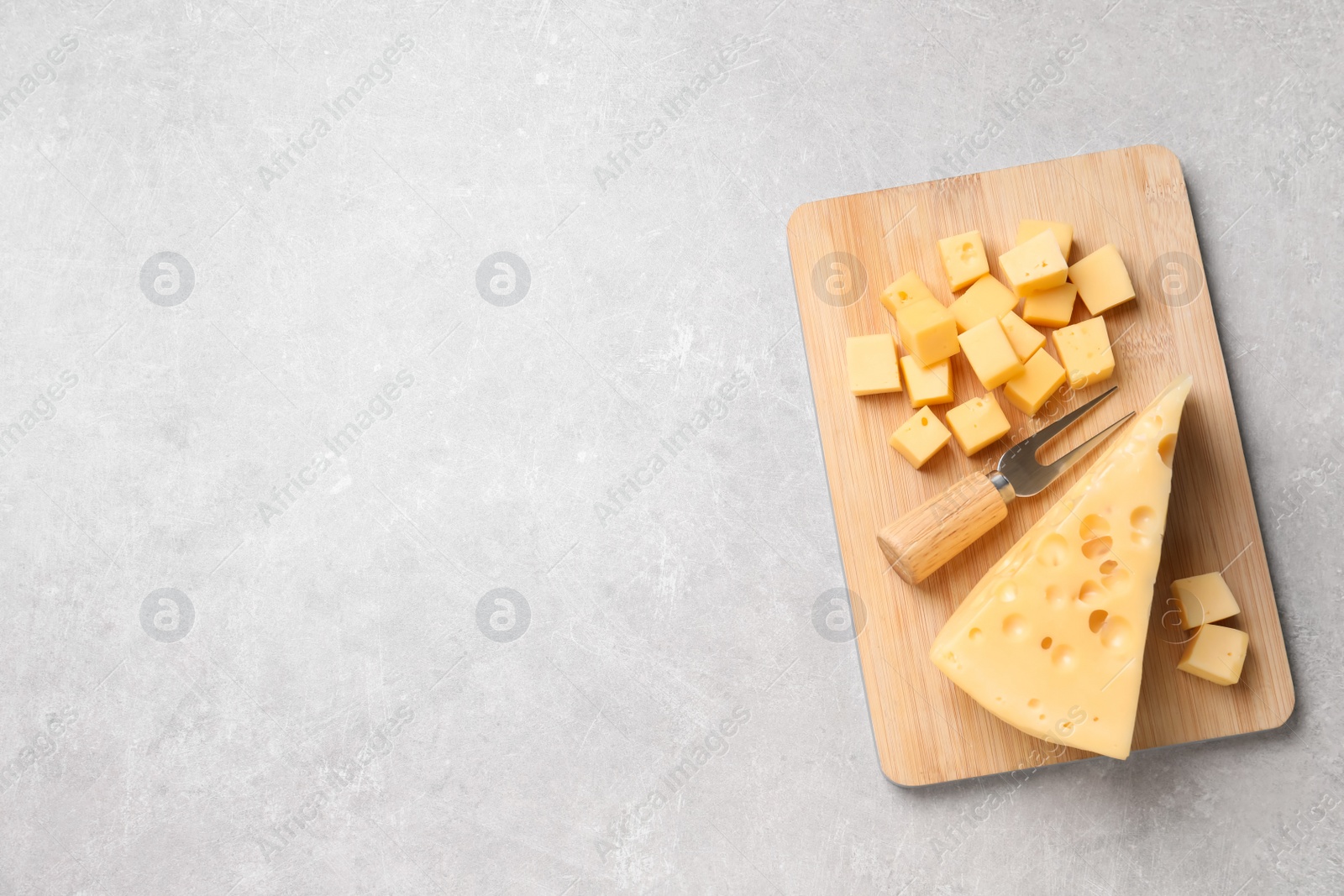 Photo of Tasty fresh cheese with fork on grey table, top view. Space for text
