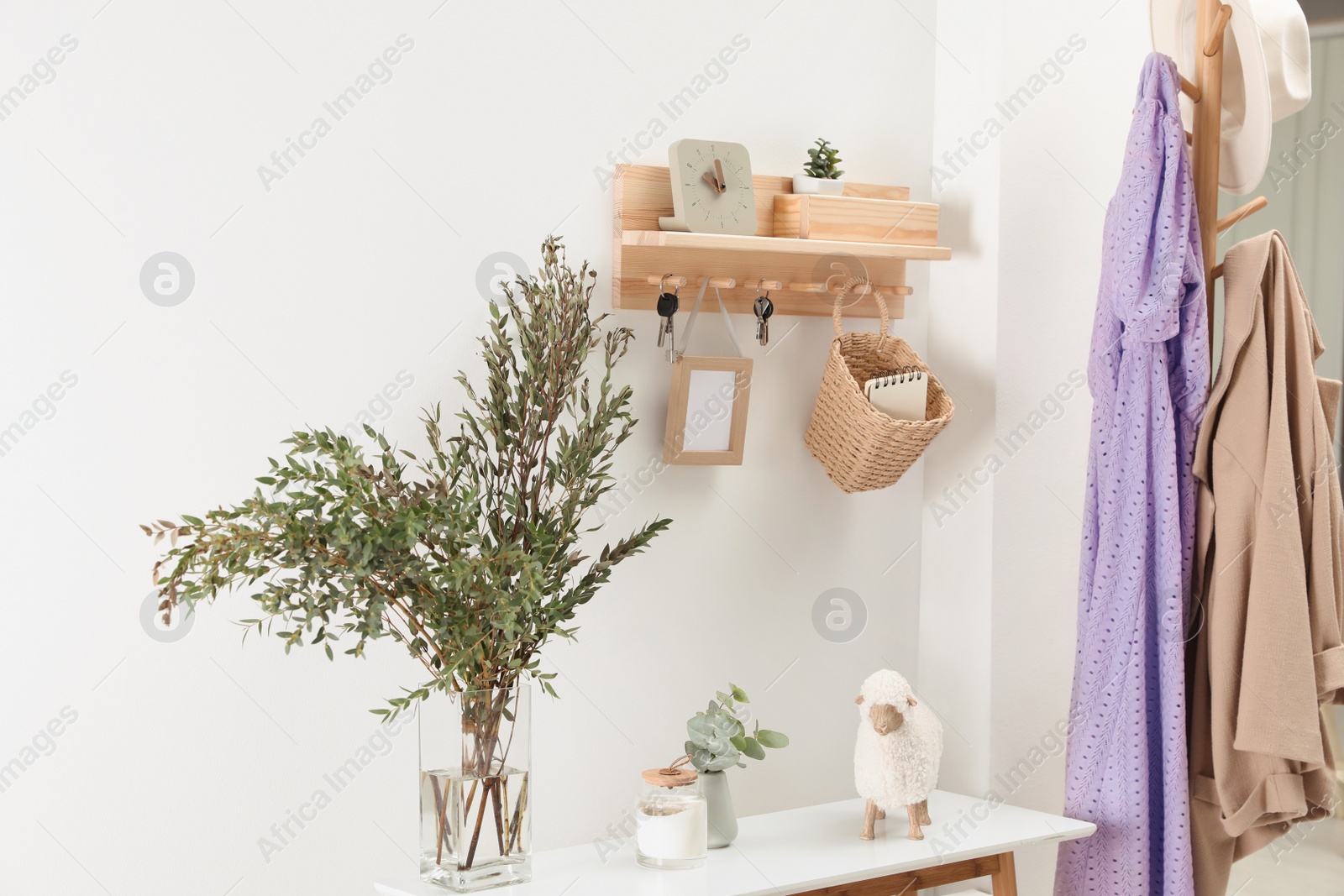 Photo of Wooden clothes rack and key holder on white wall in hallway