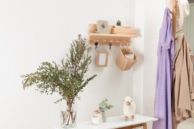 Photo of Wooden clothes rack and key holder on white wall in hallway