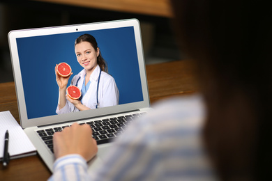 Image of Woman using laptop for online consultation with nutritionist via video chat, closeup