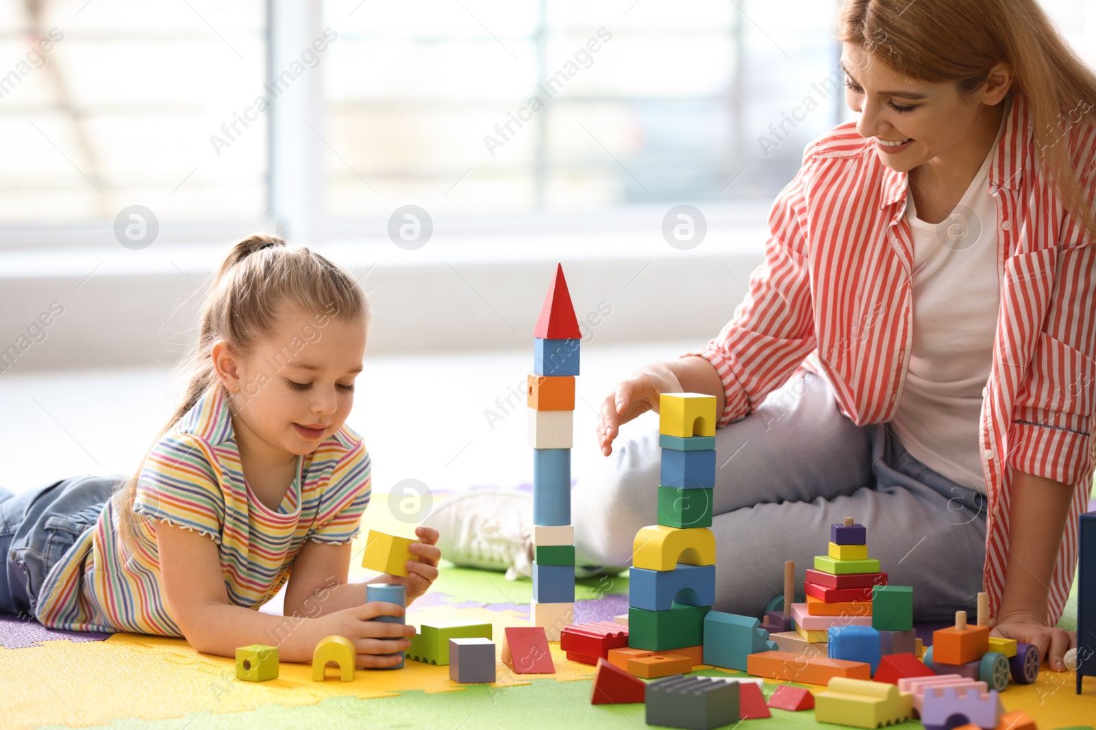 Photo of Mother playing with her children at home