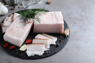 Pork fatback with spices served on grey table. Space for text