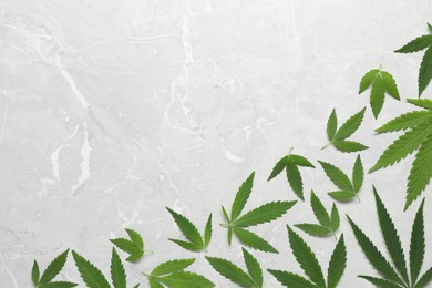 Photo of Fresh green hemp leaves on marble table, flat lay. Space for text