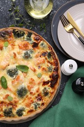 Photo of Delicious homemade salmon quiche with broccoli served on black table, flat lay