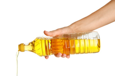 Photo of Woman pouring cooking oil from bottle on white background, closeup