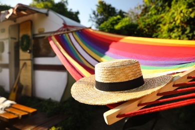 Comfortable hammock with hat near motorhome outdoors on sunny day