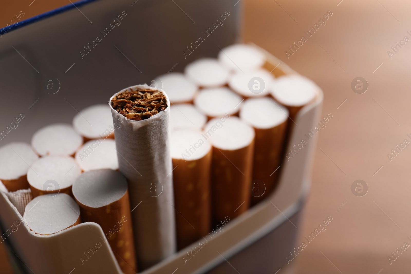 Photo of Pack of cigarettes on blurred background, closeup