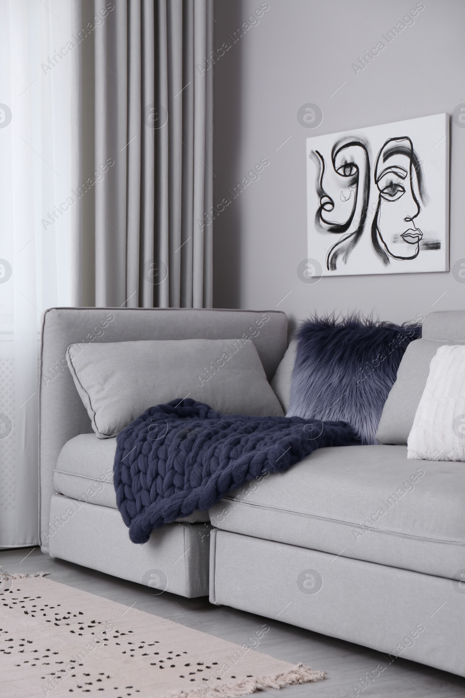 Photo of Living room interior with knitted merino wool blanket on sofa