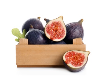 Crate with whole and cut purple figs on white background