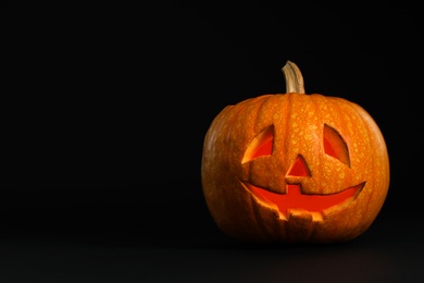 Photo of Pumpkin head on black background, space for text. Jack lantern - traditional Halloween decor