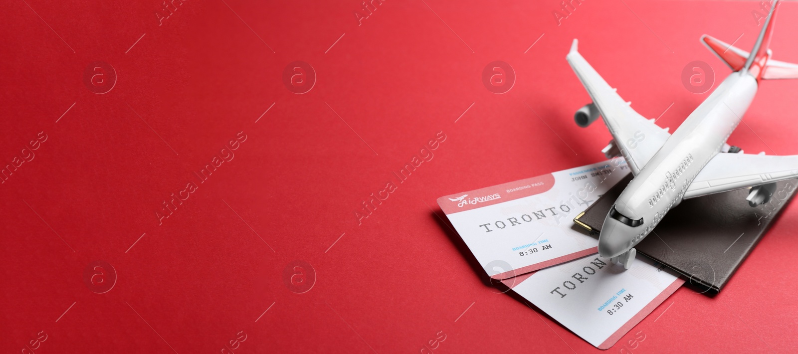 Photo of Toy airplane and passport with tickets on red background. Space for text