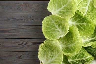 Photo of Fresh Savoy cabbage leaves on grey wooden table, flat lay. Space for text