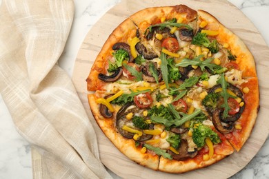 Photo of Delicious vegetarian pizza with mushrooms, vegetables and arugula on white marble table, top view