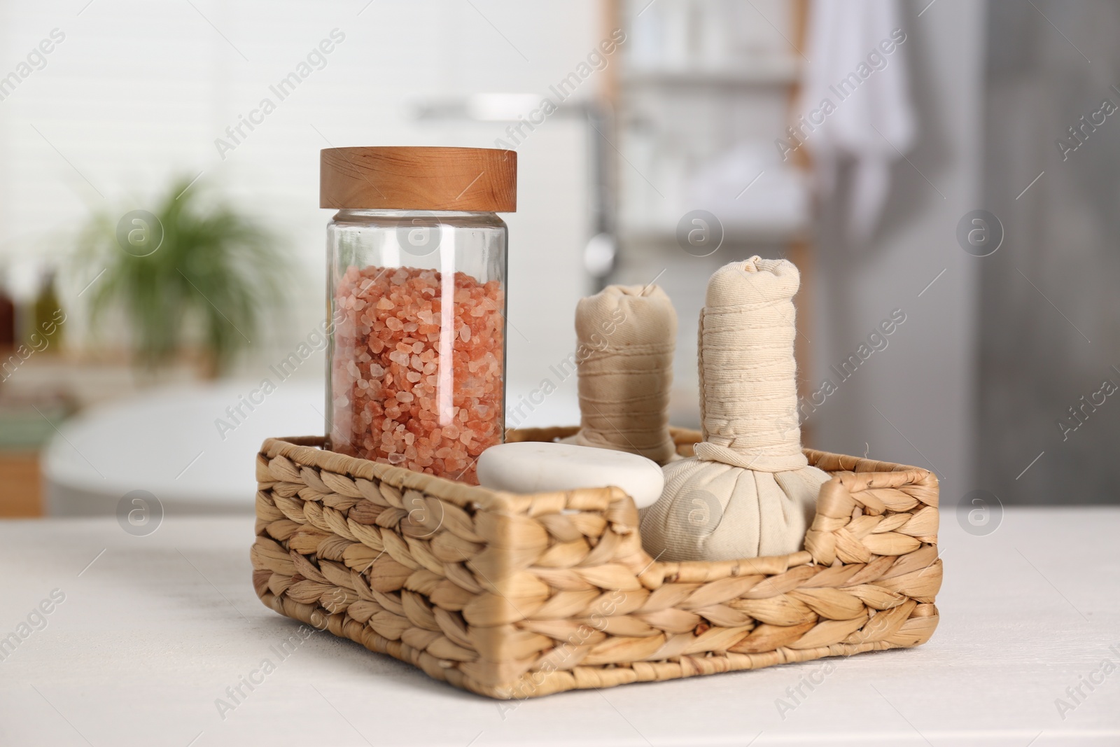 Photo of Composition with spa herbal bags on white table in bathroom, closeup