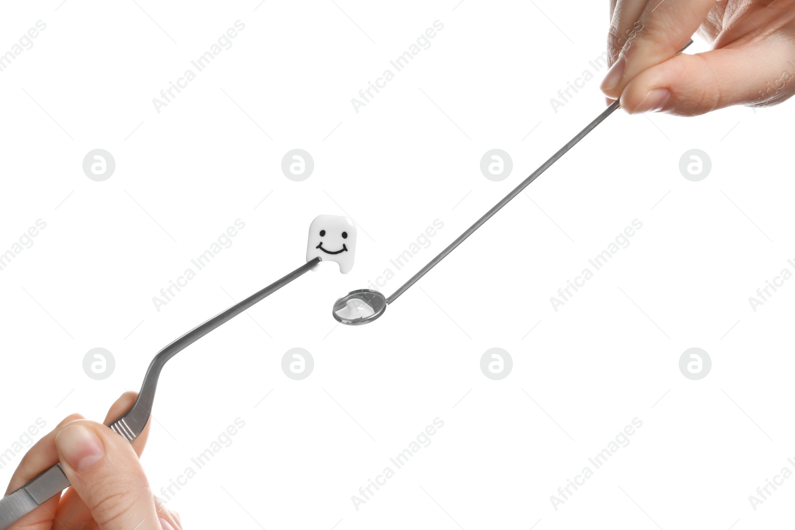 Photo of Woman holding professional dental tools and small plastic tooth on white background