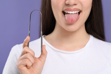 Photo of Woman with tongue cleaner on violet background, closeup