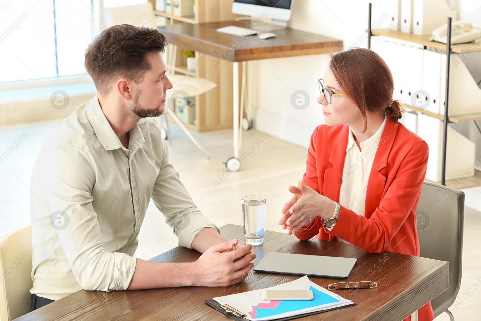 Photo of Man consulting with woman in office