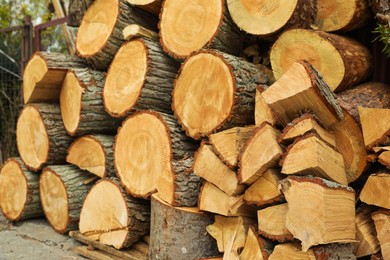 Photo of Stacked firewood outdoors, closeup. Heating in winter