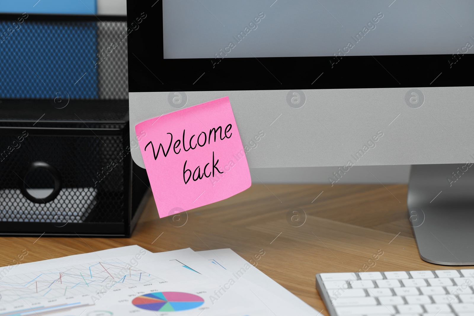 Image of Sticky note with phrase Welcome Back on computer monitor in office