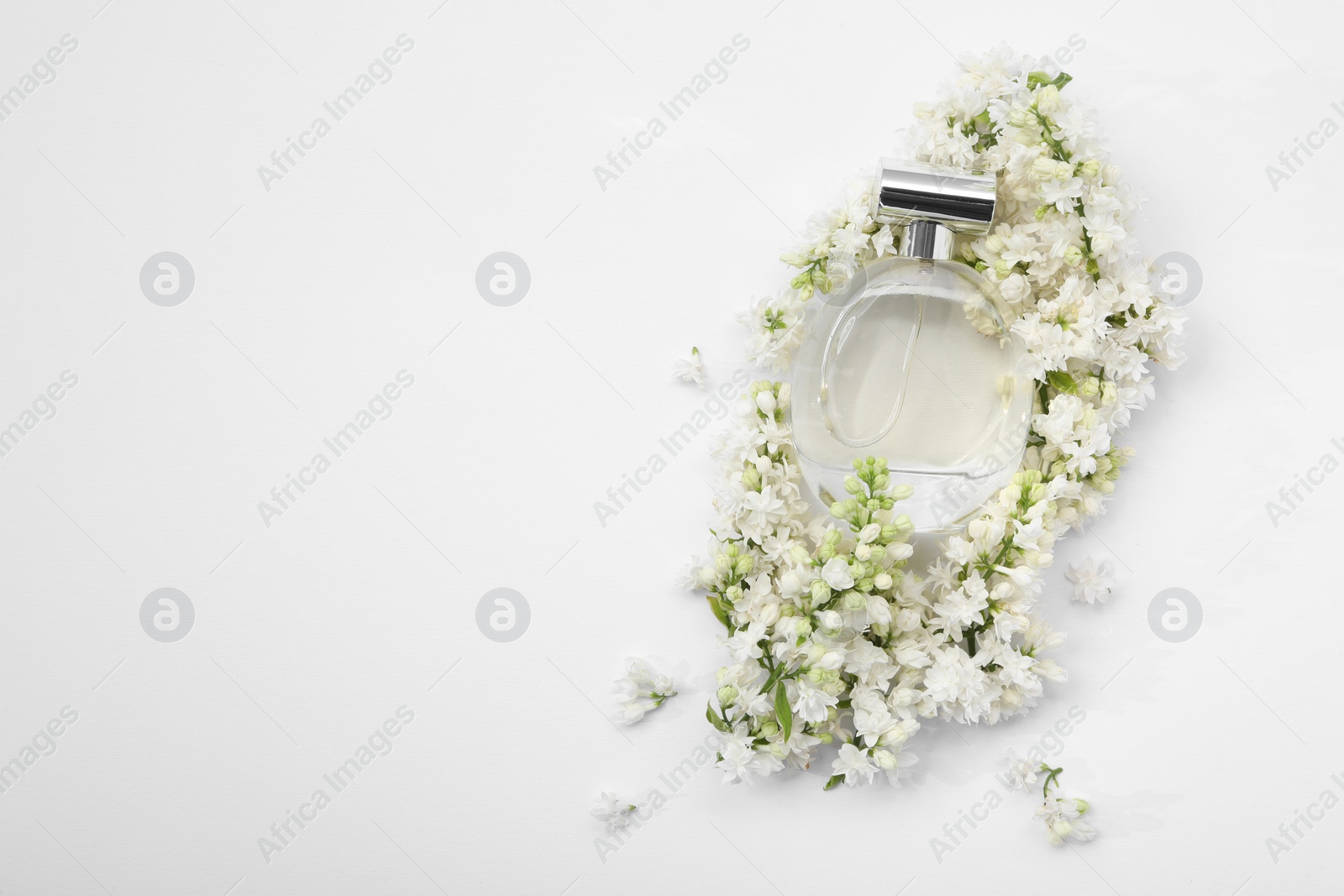 Photo of Luxury perfume and floral decor on white background, top view. Space for text