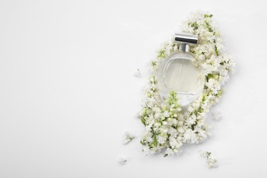 Photo of Luxury perfume and floral decor on white background, top view. Space for text