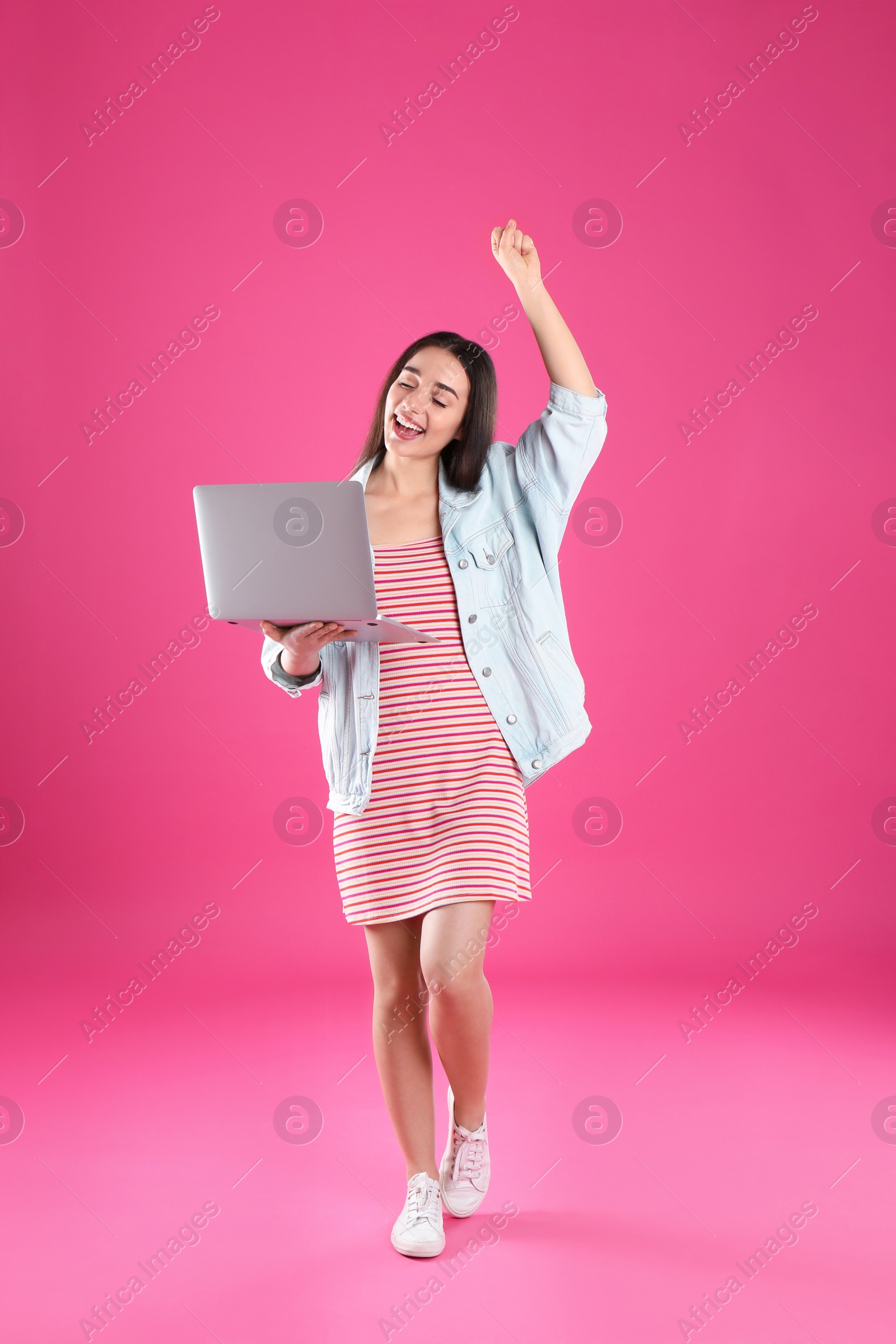 Photo of Full length portrait of happy young woman in casual outfit with laptop on color background