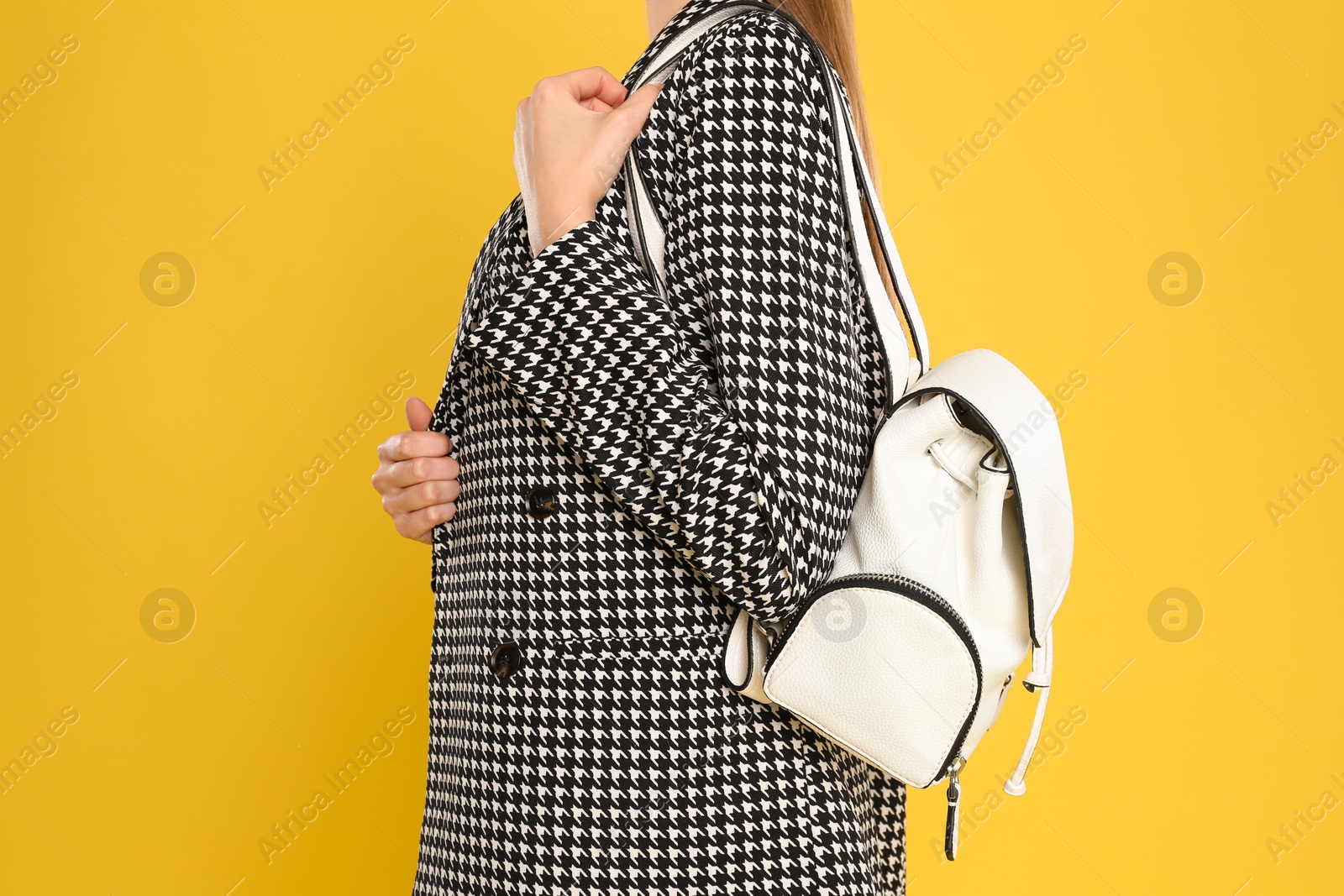 Photo of Young woman with stylish bag on yellow background, closeup