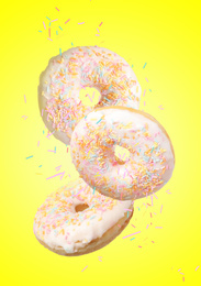 Image of Set of falling delicious donuts on yellow background