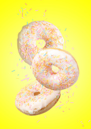 Set of falling delicious donuts on yellow background