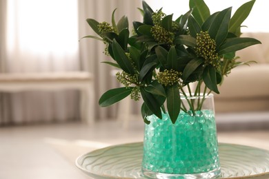 Photo of Mint filler with green branches in glass vase on table at home, space for text. Water beads