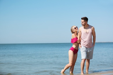 Photo of Happy young couple having fun at beach on sunny day