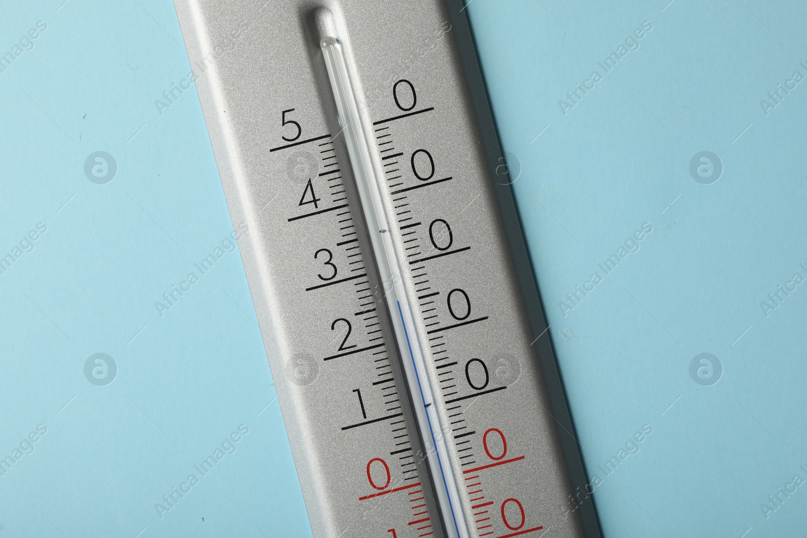 Photo of Weather thermometer on light blue background, closeup