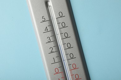 Photo of Weather thermometer on light blue background, closeup