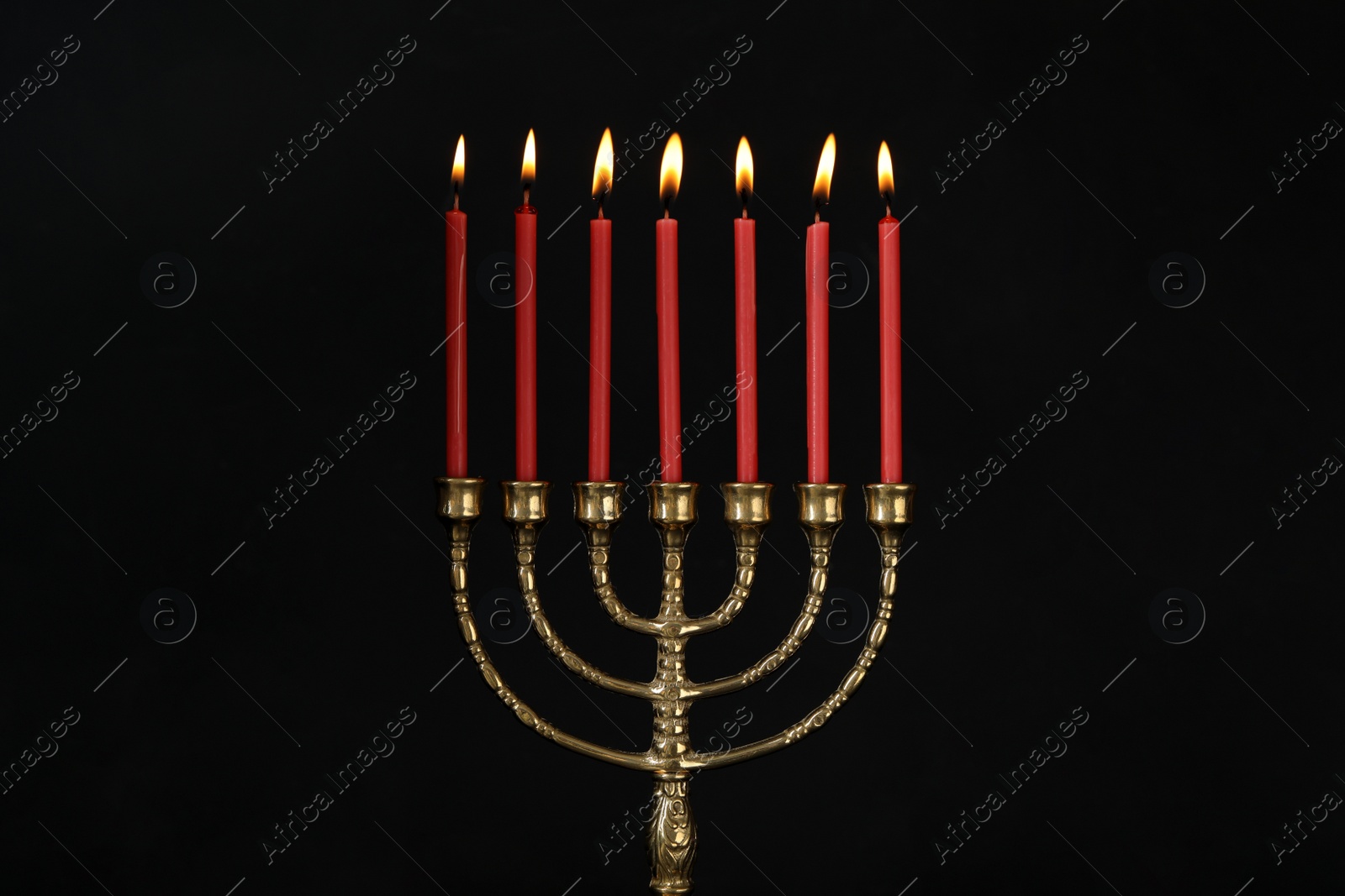 Photo of Golden menorah with burning candles on black background