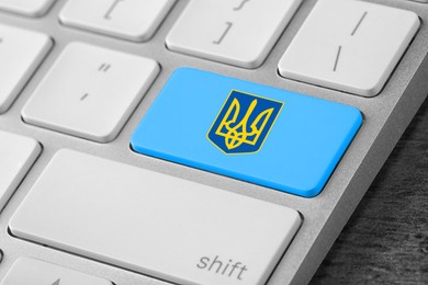 Image of Turquoise button with Ukrainian coat of arms on keyboard, top view