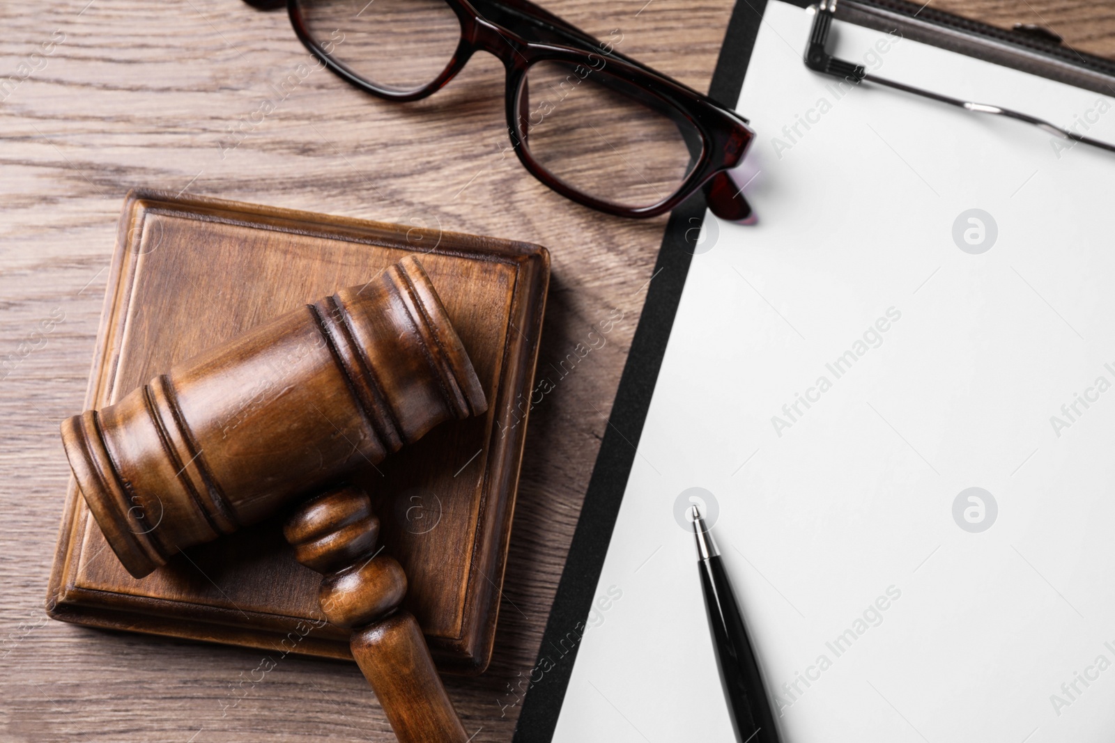 Photo of Clipboard with words DOMESTIC VIOLENCE and gavel on wooden table, flat lay. Protection of law